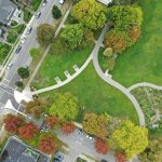 an aerial view of a park with cars parked in it