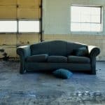 black fabric 3-seat sofa in front of wall and garage door