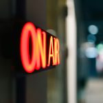 Red "on air" sign glowing in the dark