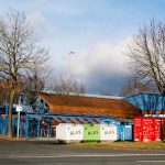 a blue building with a red roof next to a street
