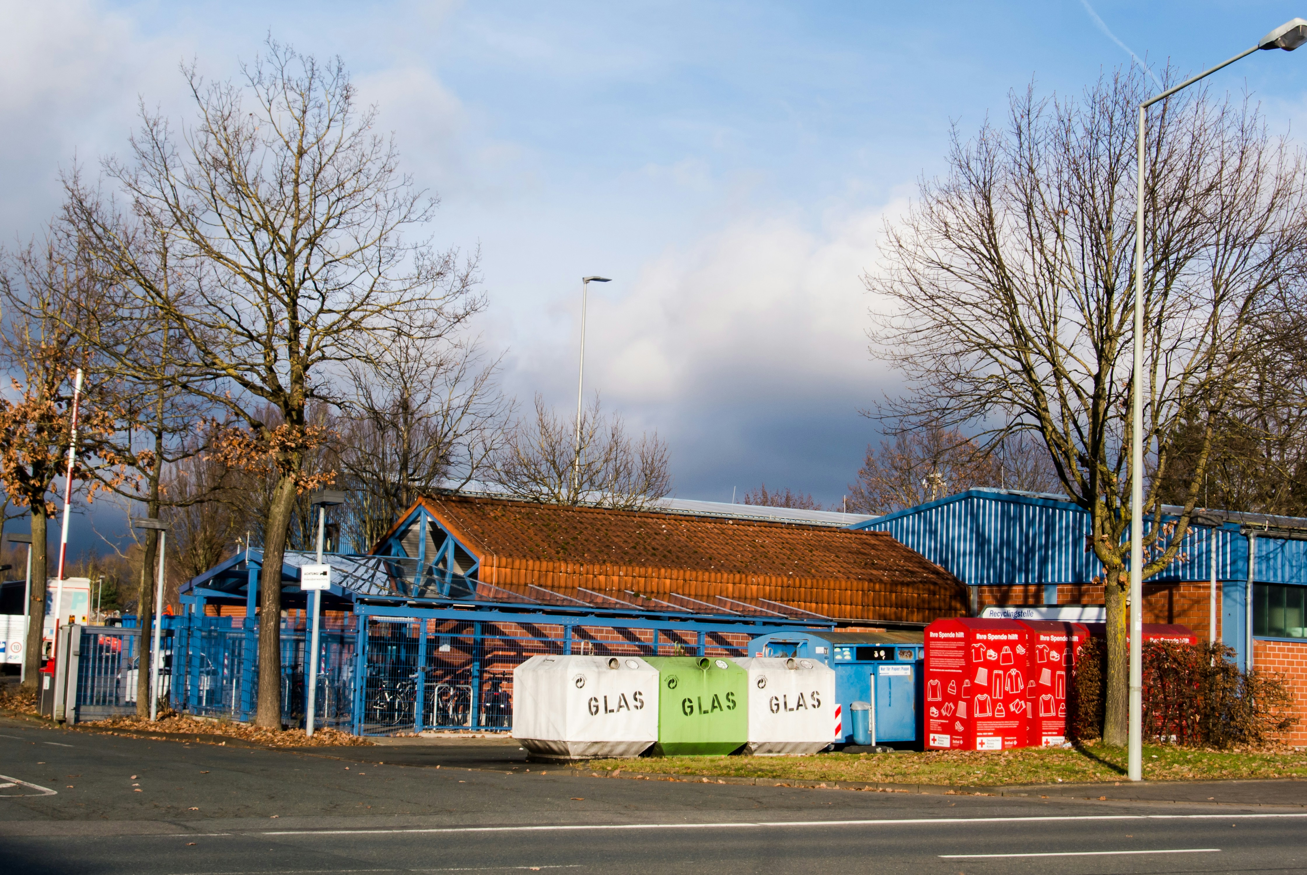 a blue building with a red roof next to a street
