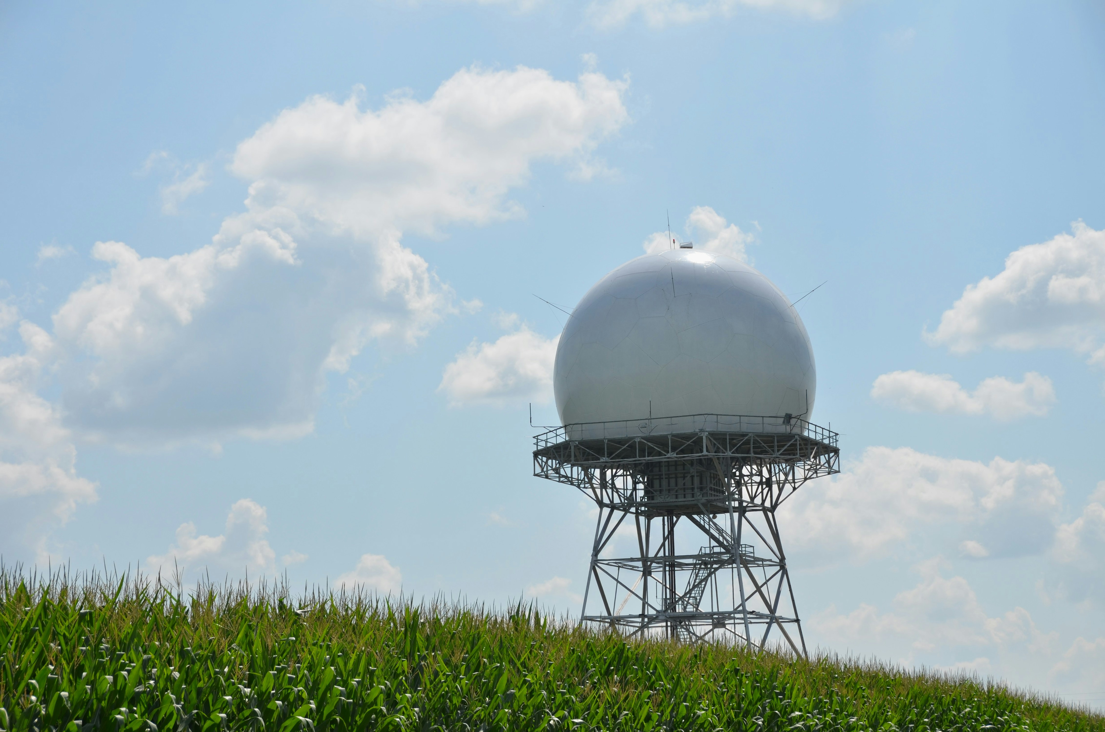 Weather radar dome on a hill with clouds