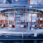 a large machine in a factory with people working on it