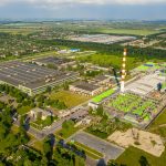 orange and white tower surrounded by green trees and buildings