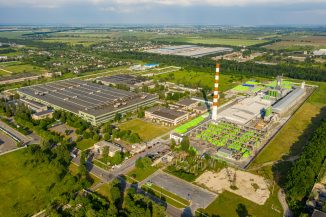 orange and white tower surrounded by green trees and buildings