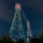 a tall tower sitting next to a lush green field