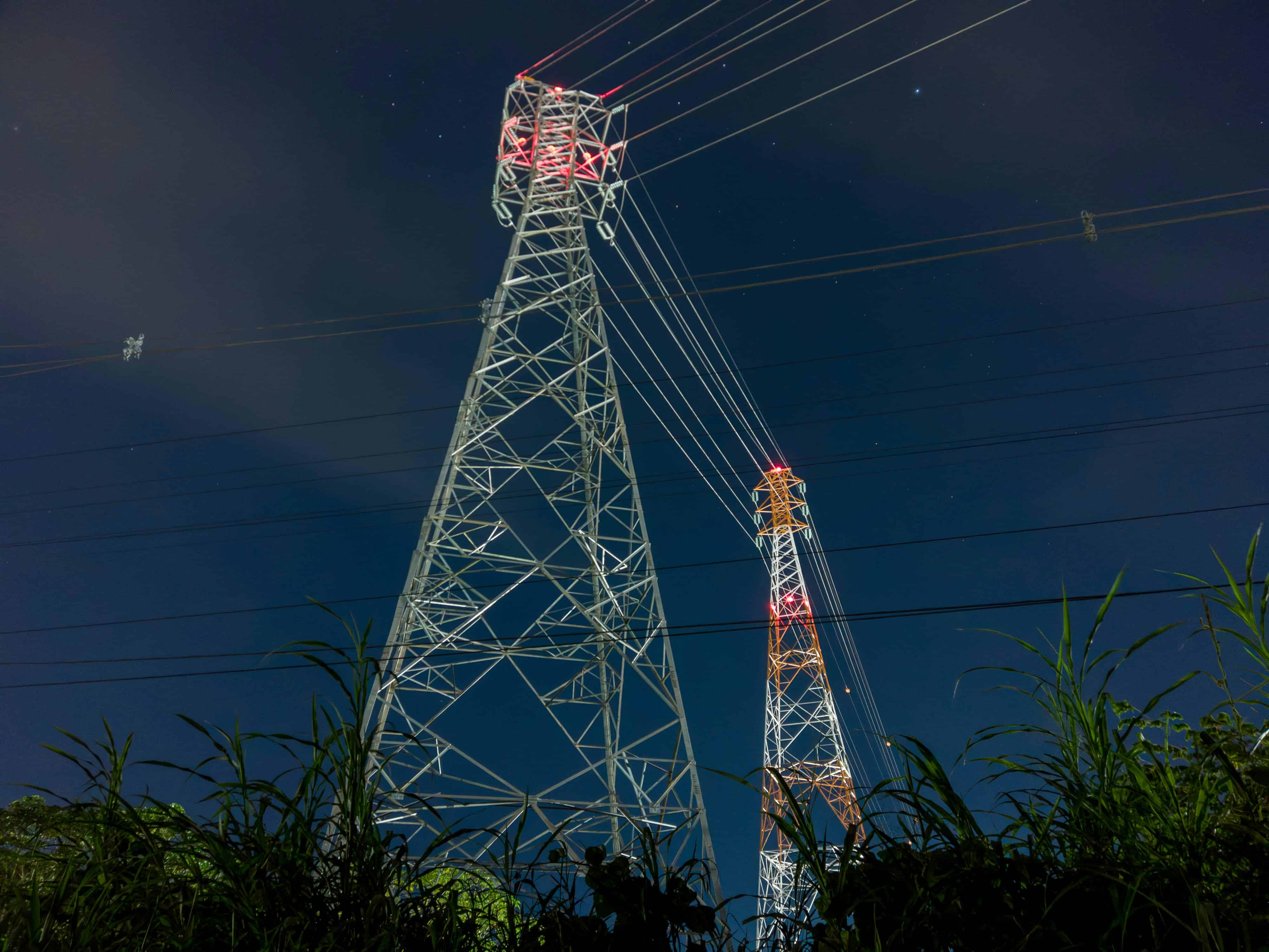 a tall tower sitting next to a lush green field