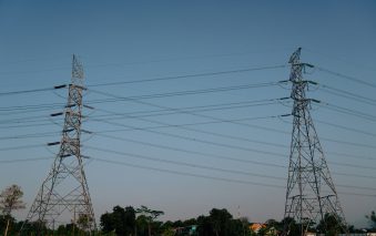 Power lines stand tall against a clear blue sky.