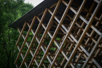 a wooden structure sitting in the middle of a forest