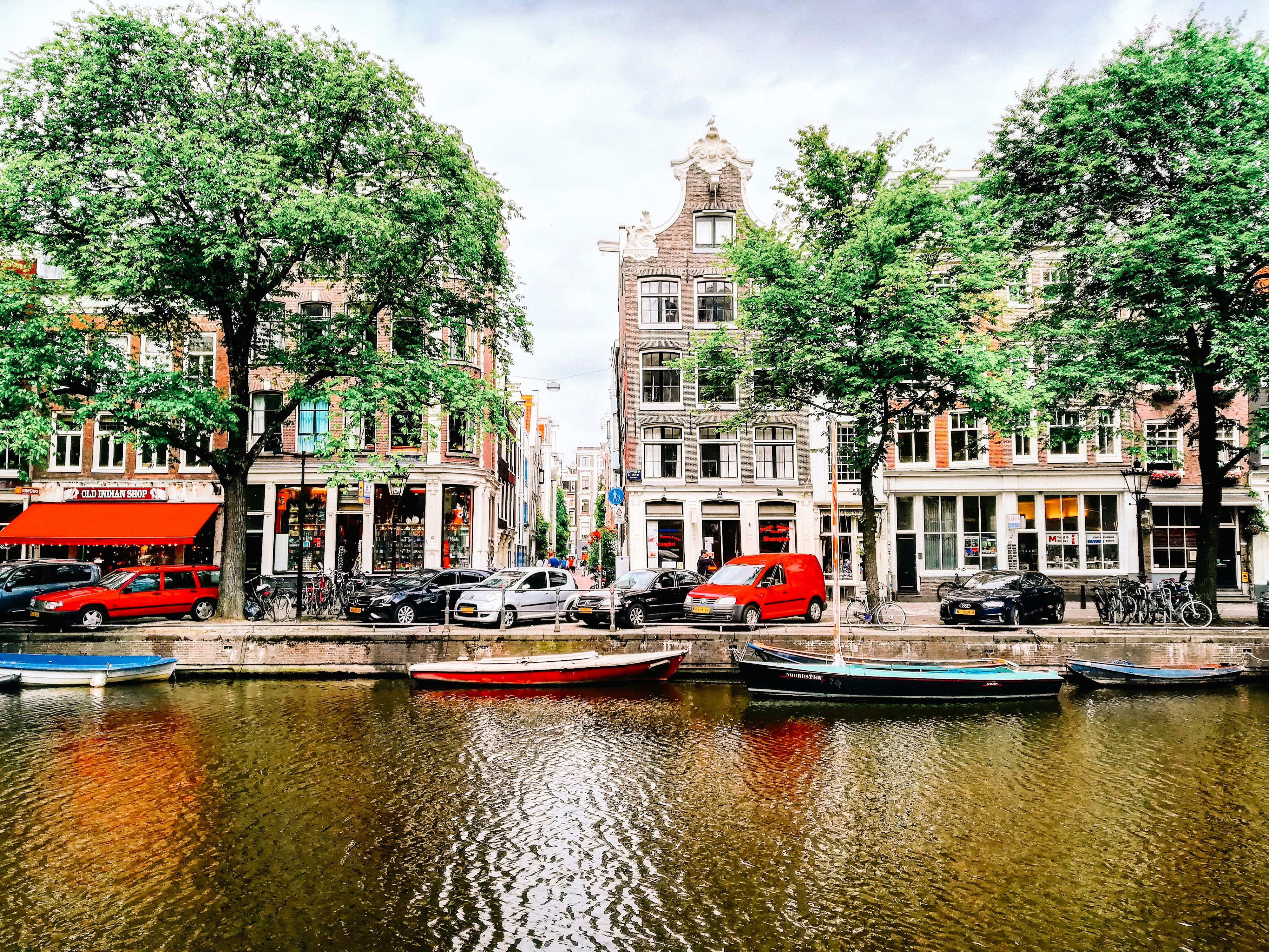 a group of boats floating on top of a river next to tall buildings