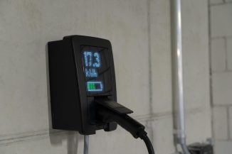 Electric car charger mounted on wall with display.