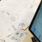 a person sitting at a table with a tablet