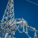 low-angle photography of electric tower under blue sky during daytime