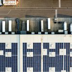 An aerial view of a parking lot with lots of solar panels