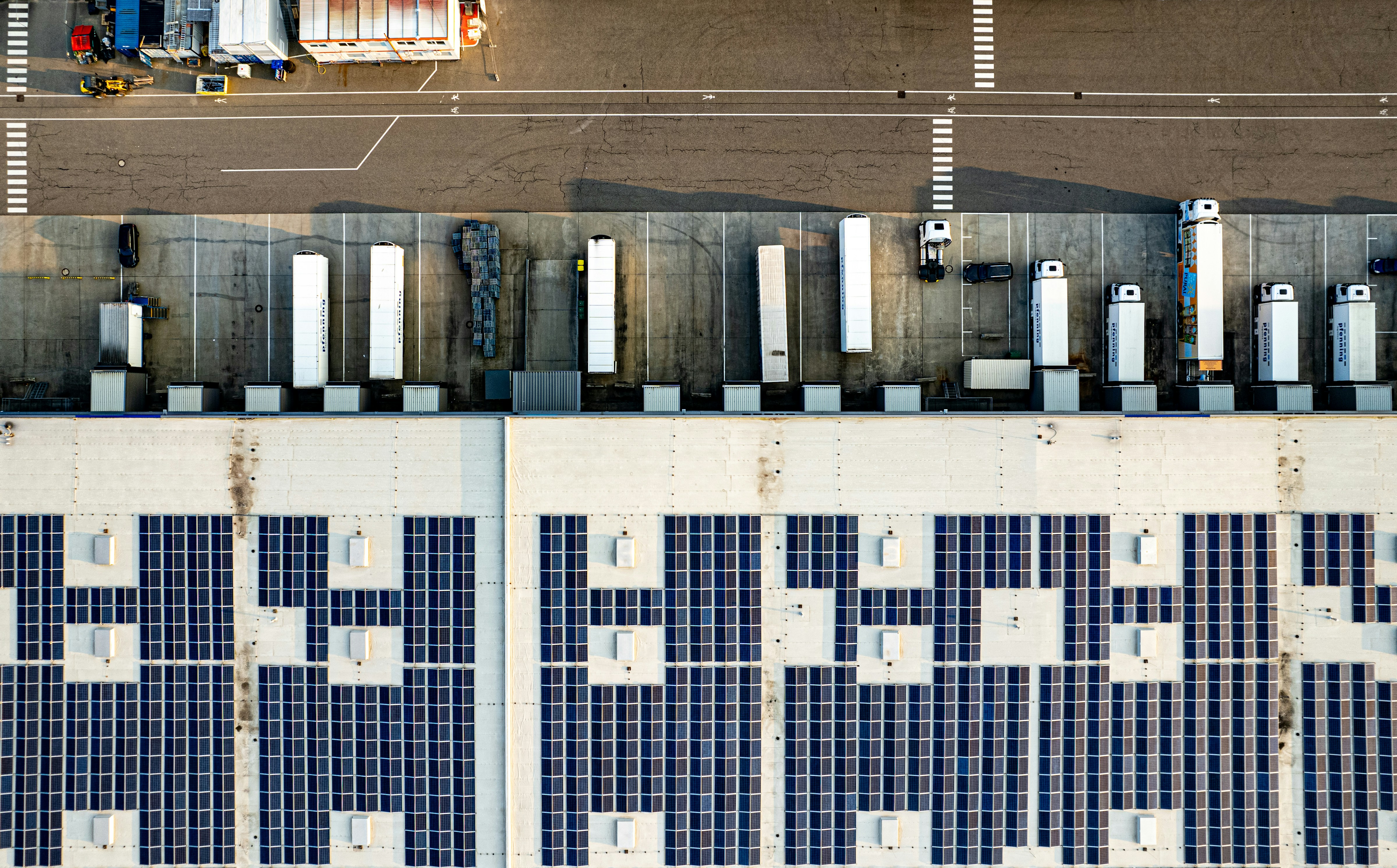 An aerial view of a parking lot with lots of solar panels
