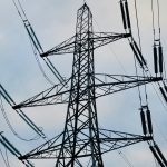 a high voltage power line against a cloudy sky