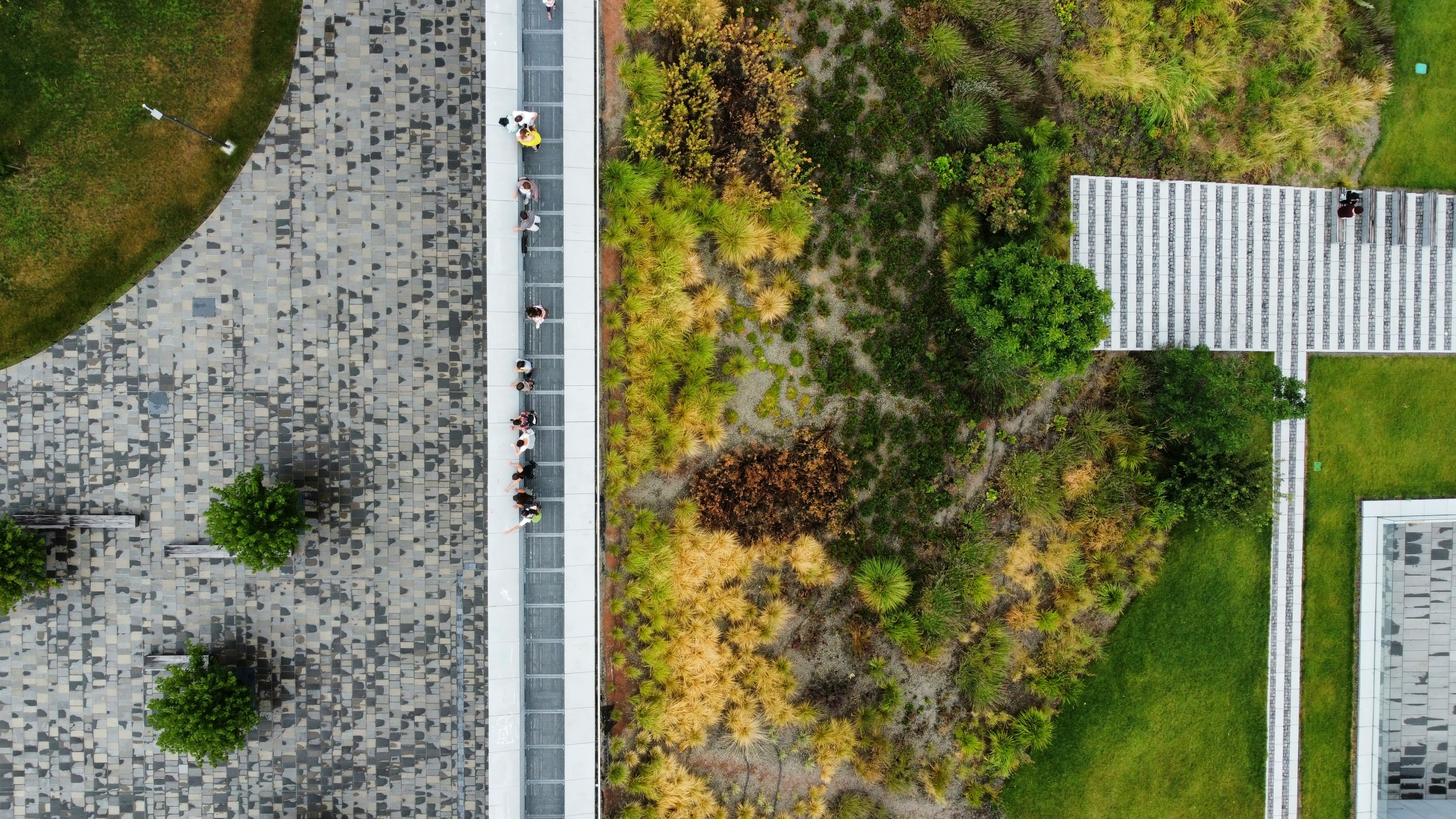 Aerial view of a modern landscape with greenery and paving.