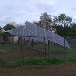 a fence with a bunch of solar panels on top of it