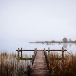 a wooden dock over a body of water with boats in it