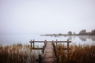 a wooden dock over a body of water with boats in it
