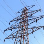 brown and gray electric towers under blue sky during daytime