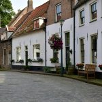 a cobblestone street lined with white buildings