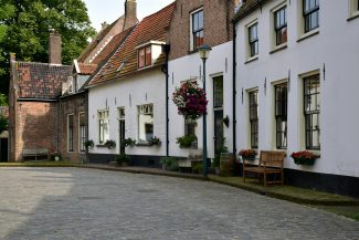 a cobblestone street lined with white buildings